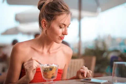 拿着银器看手机的女人