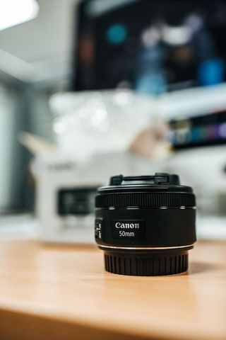 桌上的黑色佳能 50 毫米相机镜头