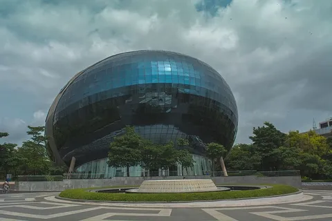 绿树旁的蓝色玻璃建筑