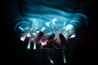 拿着白色灯串的人