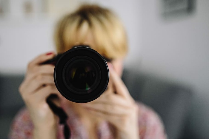 穿着粉红色衣服拿着相机的女人