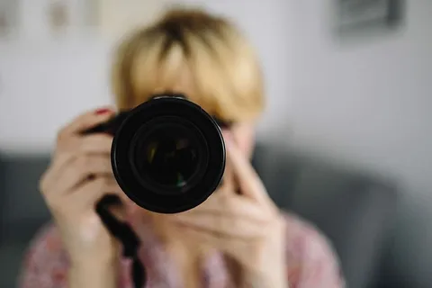 穿着粉红色衣服拿着相机的女人