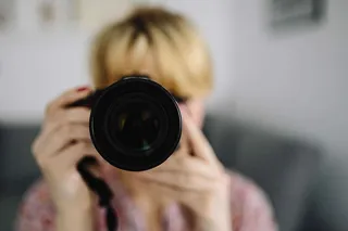 穿着粉红色衣服拿着相机的女人