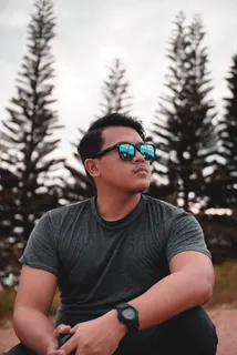 松树旁穿着灰色圆领T恤的男子