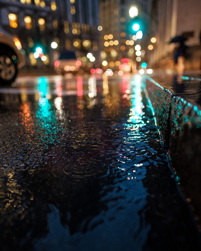 这是一张夜间图像，拍摄了市中心街道上的雨水。