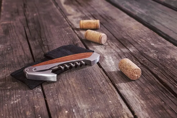 开瓶器旁边有三个棕色软木塞