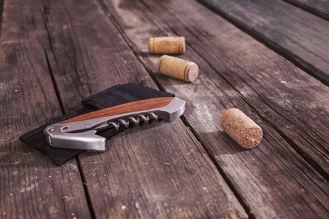 开瓶器旁边有三个棕色软木塞