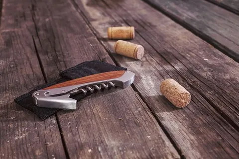 开瓶器旁边有三个棕色软木塞