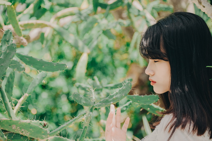 站在附近触摸仙人掌的女人