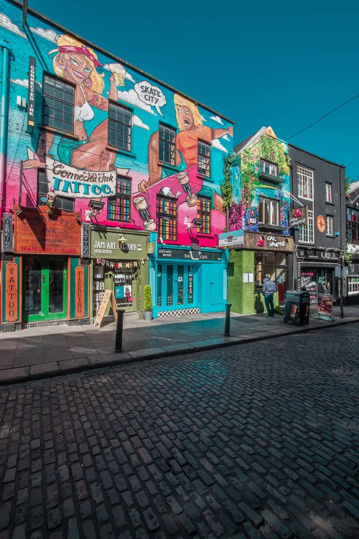 白天站在路边绿色建筑前的人