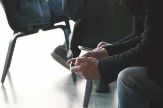 坐在椅子上使用智能手机特写照片的人