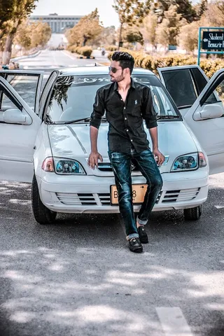 坐在白色汽车引擎盖上的男人