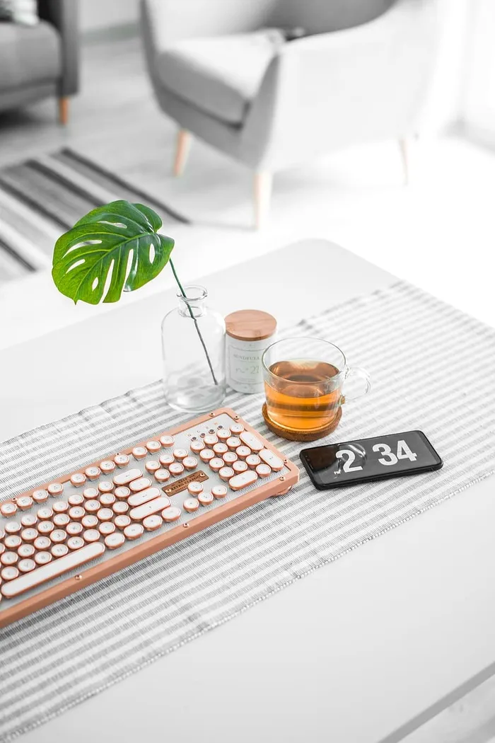 玻璃杯子旁边的棕色电脑键盘