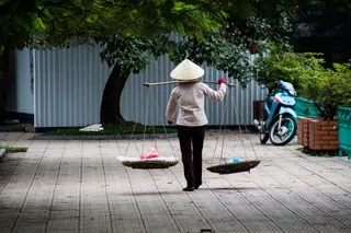 从杆子上提两个篮子的人