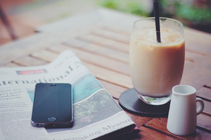 在饮水杯附近的报纸上拍摄太空灰iPhone 5S