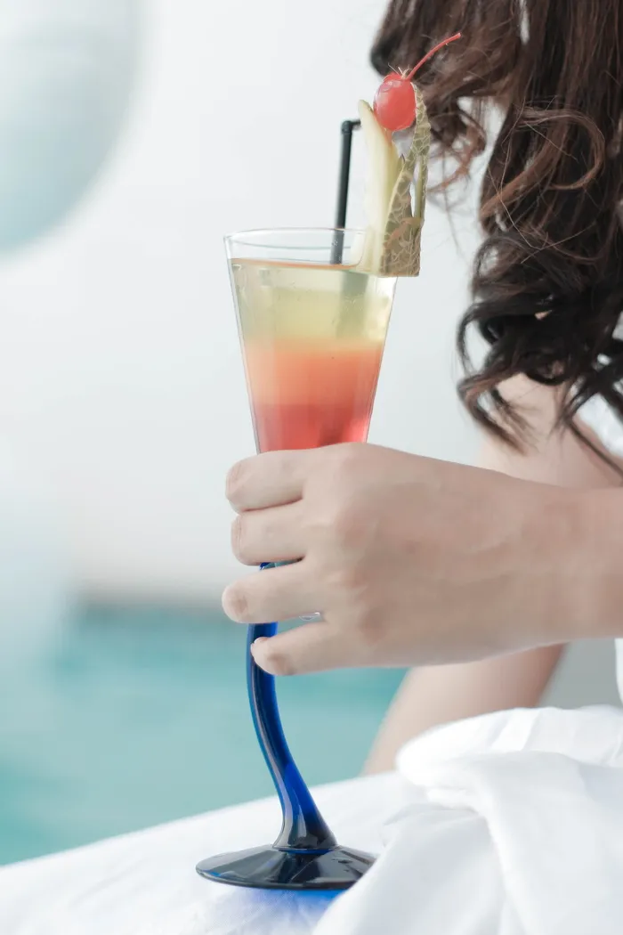 一个拿着装满液体的玻璃杯的女人