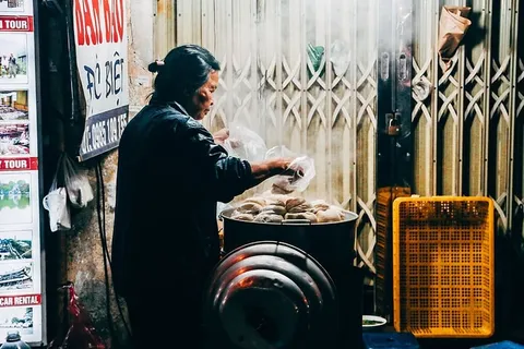 照片中,一名身穿灰色长袖上衣的女子手持塑料袋 照片中,一名身穿灰色长袖上衣的女子手持塑料袋