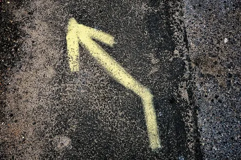 黑色和灰色表面上的黄色左箭头标志 黑色和灰色表面上的黄色左箭头标志