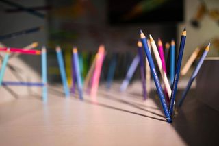 铅笔和蜡笔从墙上和地板上伸出来