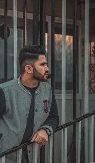 靠在黑色金属楼梯栏杆旁的男子