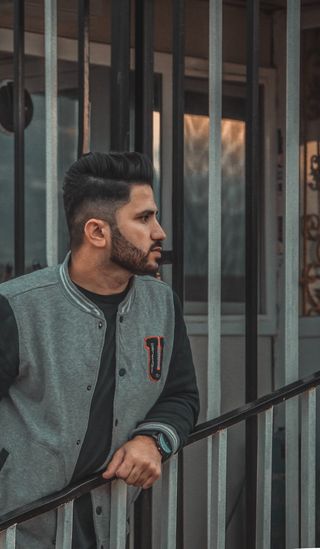 靠在黑色金属楼梯栏杆旁的男子