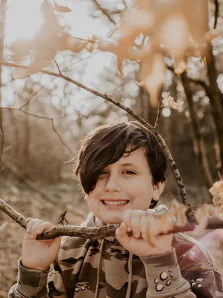 树旁穿着灰色和黑色套头衫连帽衫的人