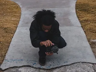 蹲着拿着相机的男人