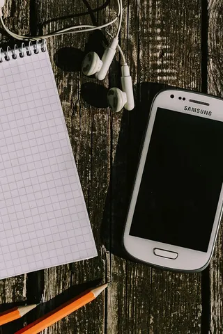 木质背景上有各种物品的白色智能手机