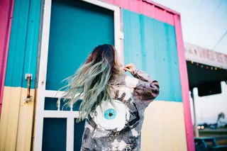 站在联运集装箱旁边的一名身穿灰色牛仔夹克的女子