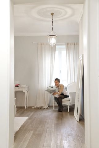 坐在白色椅子上拿着鲜花的女人