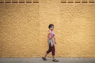 走在黄色水泥墙旁的女人