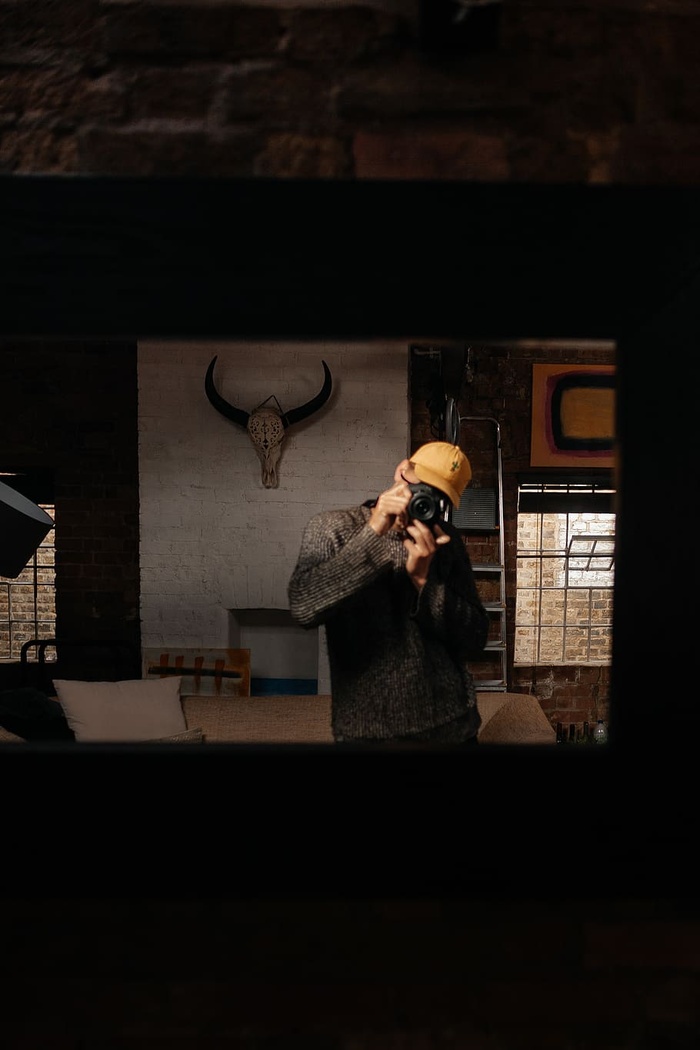 房间里站在灰色和黑色动物头骨装饰附近的人