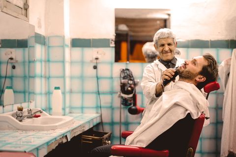 男人在椅子上刮胡子