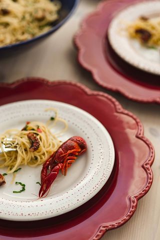 精美的晚餐，搭配海鲜意大利面、小龙虾和红酒，餐桌上装饰着玫瑰