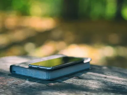 将灰色iPhone 6置于黑皮书照片上方 将灰色iPhone 6置于黑皮书照片上方