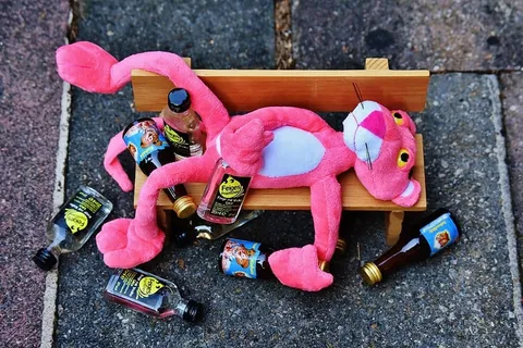 迷你长凳上瓶子旁边的粉色豹子毛绒玩具 迷你长凳上瓶子旁边的粉色豹子毛绒玩具