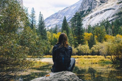 坐在池水旁岩石上的女人