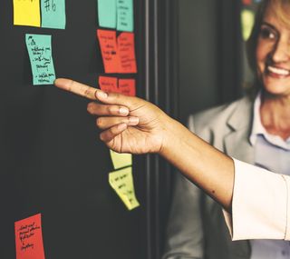 指向蓝色便笺簿的人