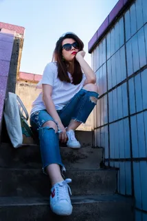 坐在楼梯上手提包旁边的女人 坐在楼梯上手提包旁边的女人