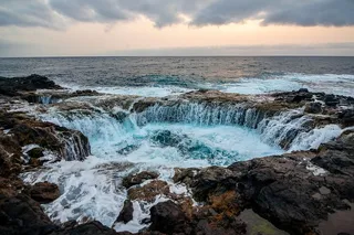 在多云的白天，瀑布划过地平线
