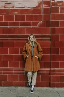 靠在红色陶瓷墙上的女人