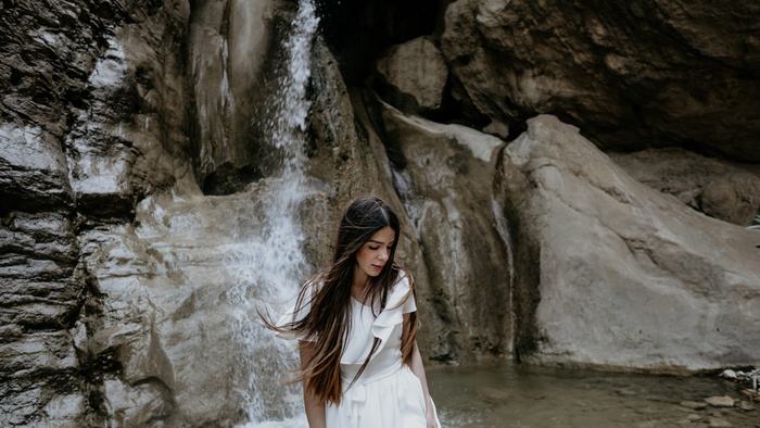 一个女人站在瀑布附近
