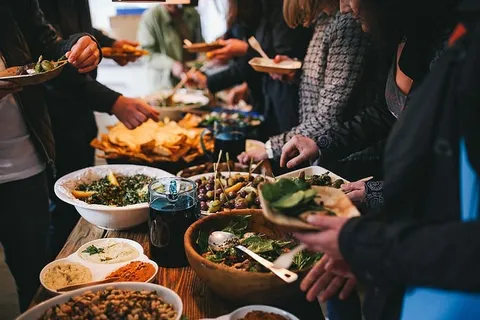 人们坐在摆满食物的餐桌旁 人们坐在摆满食物的餐桌旁