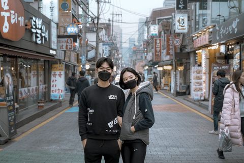 两男一女戴口罩在大楼之间