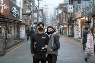 两男一女戴口罩在大楼之间