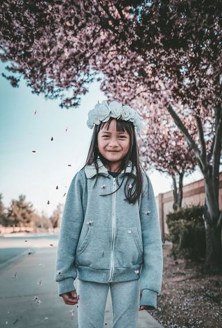 女孩穿着灰色拉链连帽衫和带花冠的裤子