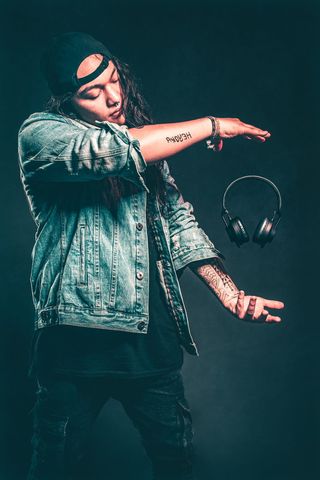 穿着蓝色牛仔夹克的男士，黑色浮动耳机