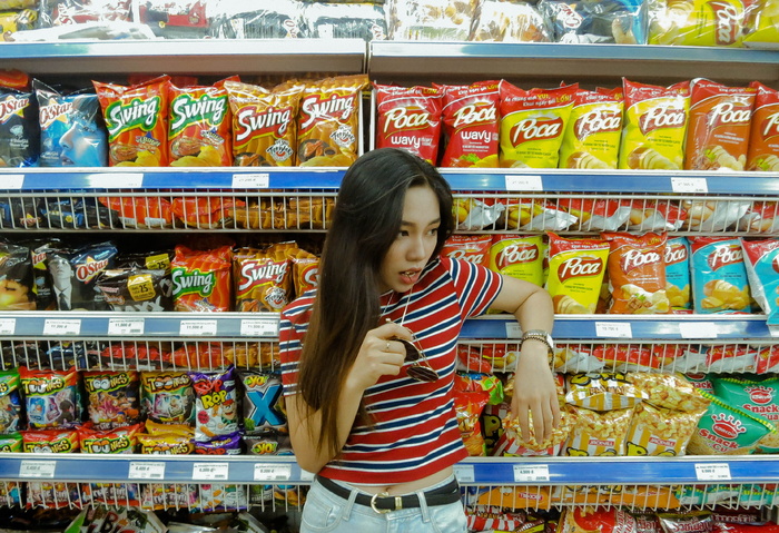 吃棒棒糖时倚在架子上的女人
