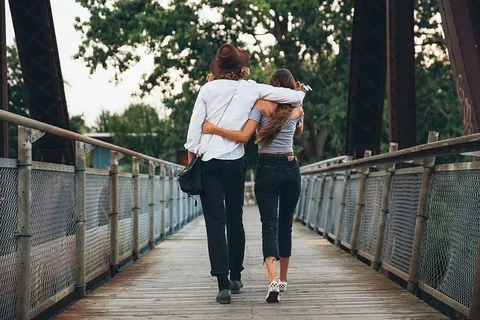 日落时分,一对年轻的白人夫妇在桥上 日落时分,一对年轻的白人夫妇在桥上