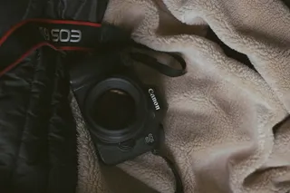 白色床毯上的黑色佳能 EOS 6D